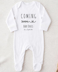 A white onesie with the text "COMING soon BABY DAVIS Due Sept 2016" printed on it.