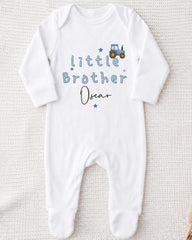 A white onesie with the text "Little Brother Oscar" printed on it, along with a small tractor graphic.