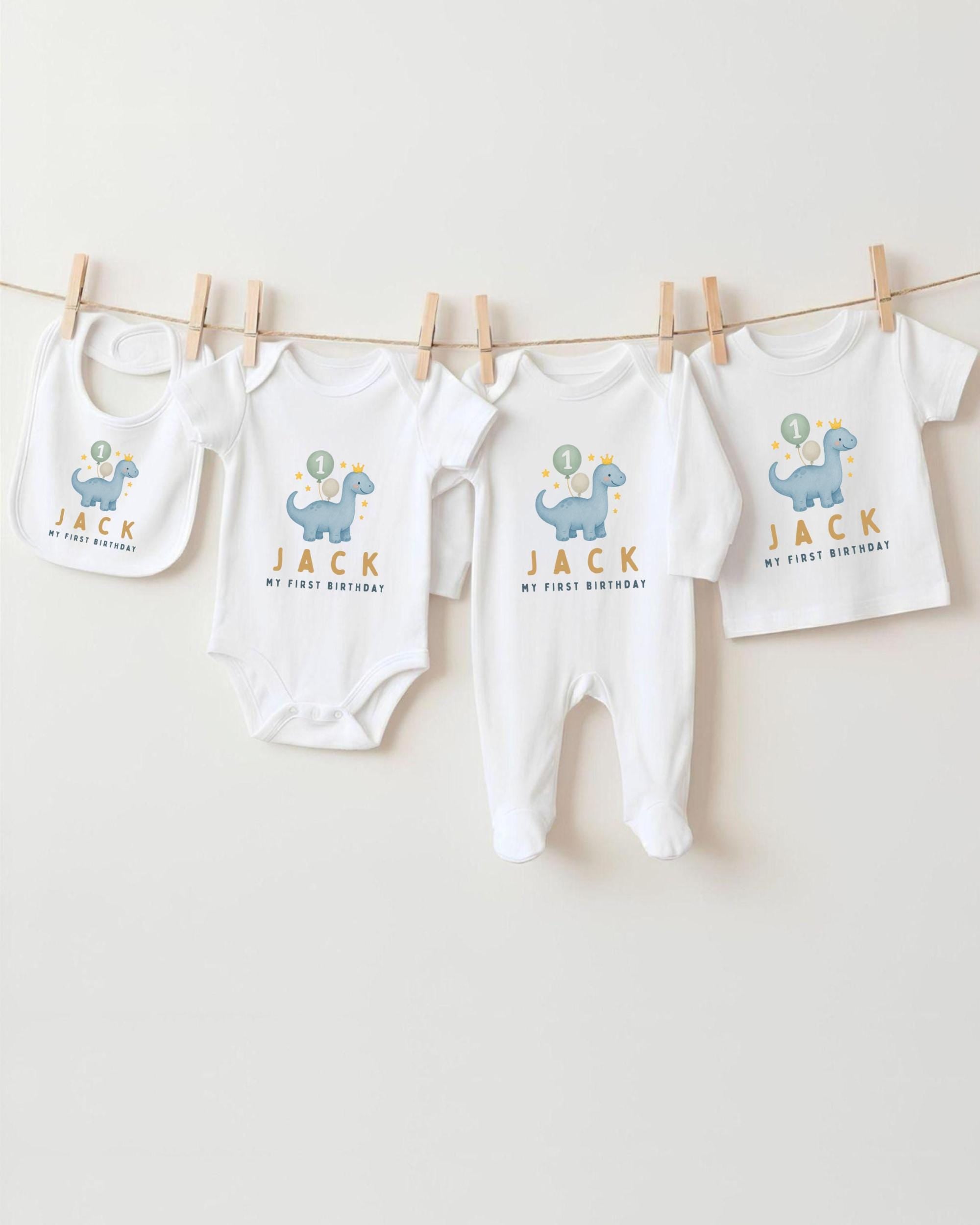 A collection of baby clothes, including onesies and bibs, hanging on a clothesline.