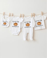 A row of four white baby clothes with pumpkin designs, each with the text "Mummy's Little pumpkin" printed on them.