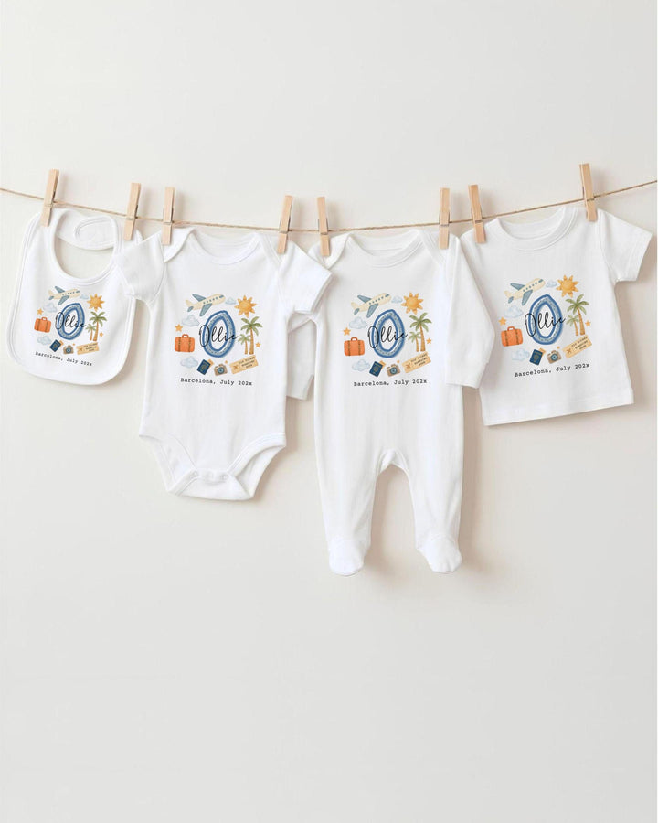 A collection of baby clothes, including onesies and bibs, hanging on a clothesline.