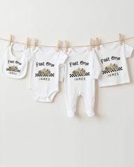 A collection of white baby clothes, including onesies and bibs, hanging on a clothesline.