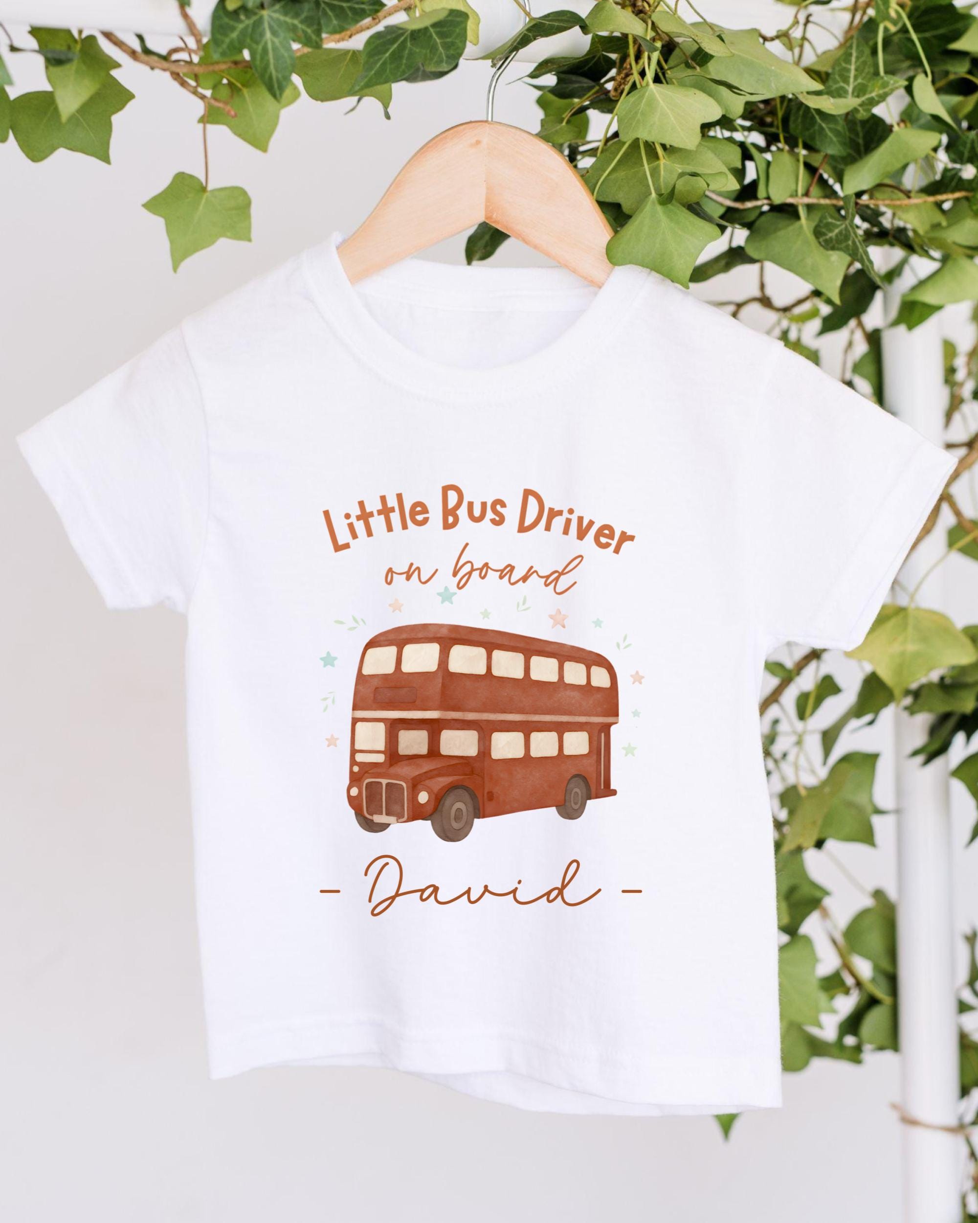 A white t-shirt with a printed design of a double-decker bus and the text "Little Bus Driver on board David" printed on it.
