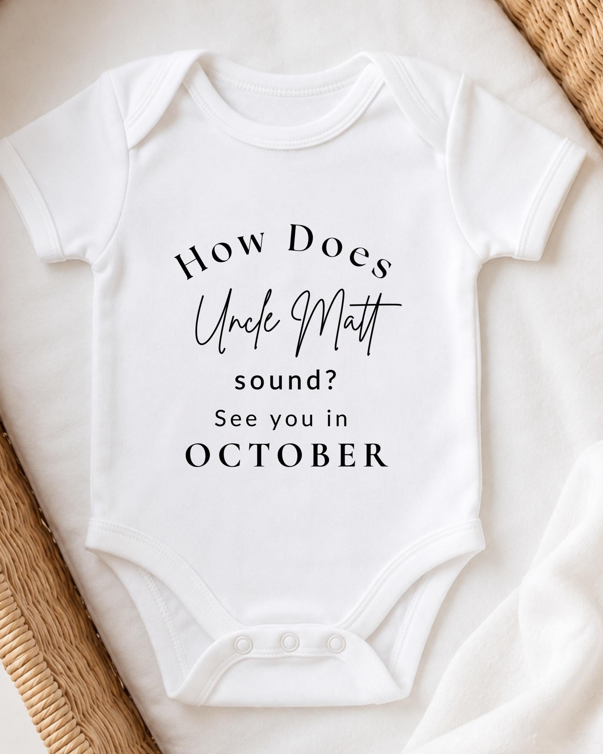 A white baby onesie with text printed on it.