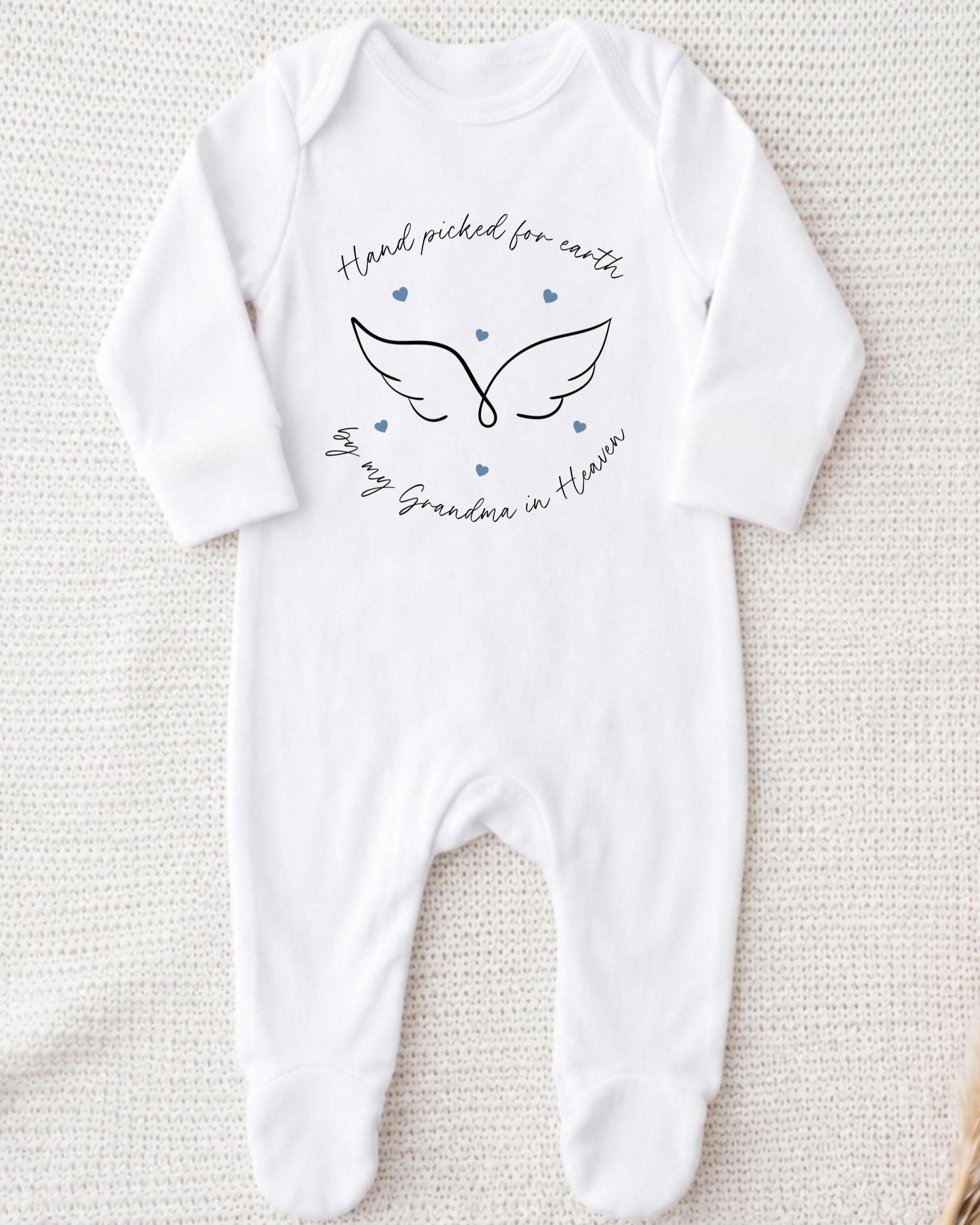 A white onesie with a graphic design and text on it.