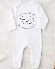 A white onesie with a graphic design and text on it.