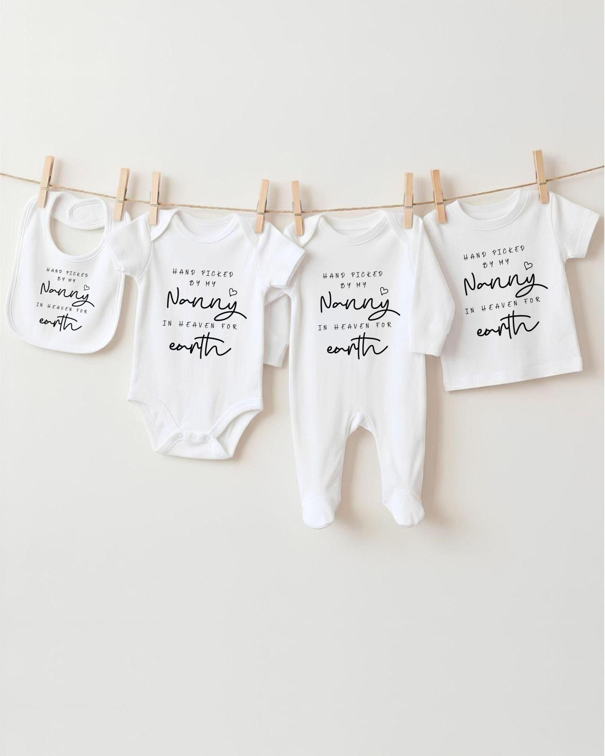 A row of four white baby clothes hanging on a clothesline, each with a unique message printed on it.