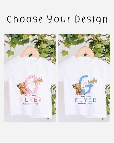 two white t-shirts with a design featuring a pink and blue airplane and a teddy bear. The text on the t-shirts reads "First time flyer Tenerife, 2020".