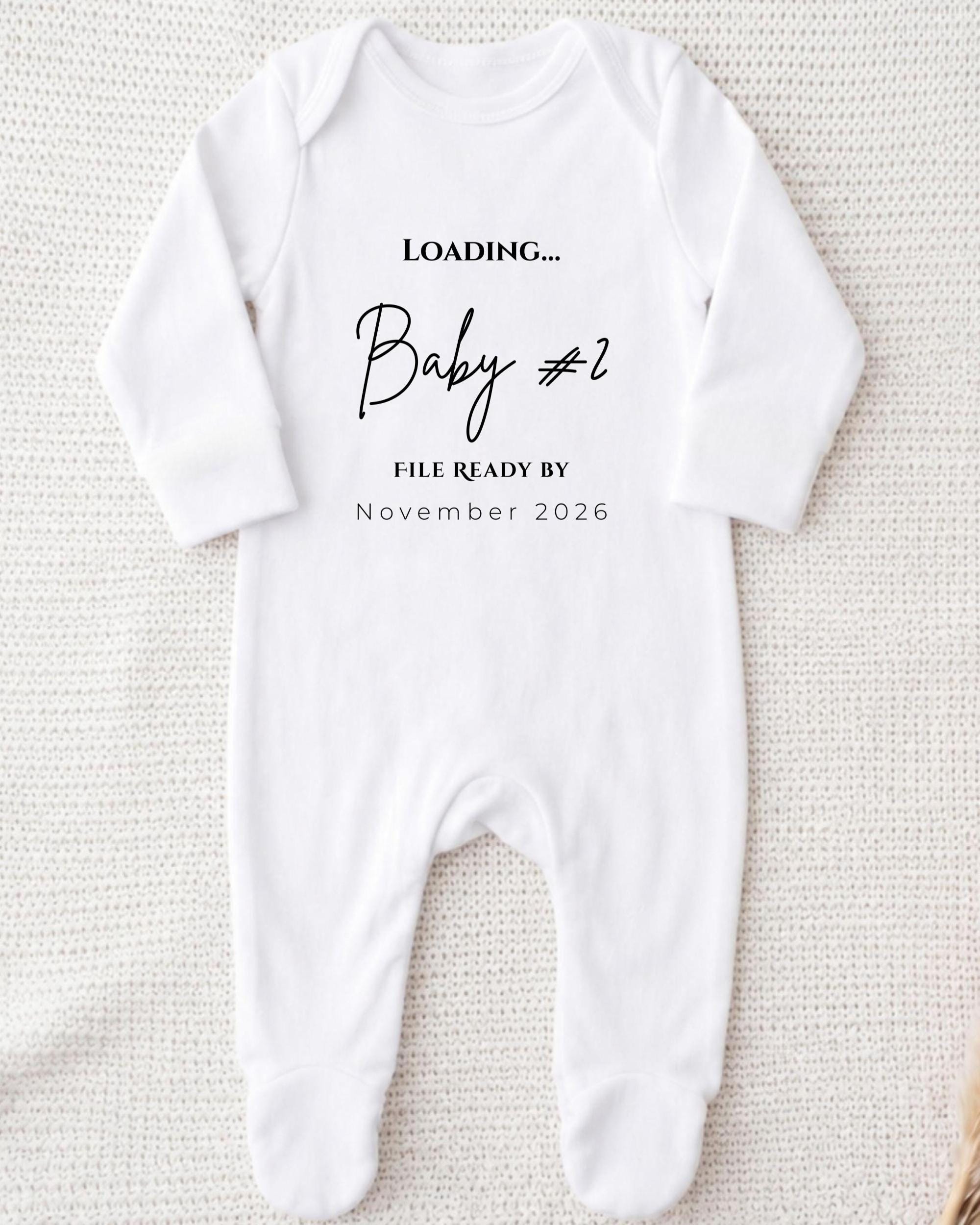 A white onesie with text printed on it, placed on a white background.