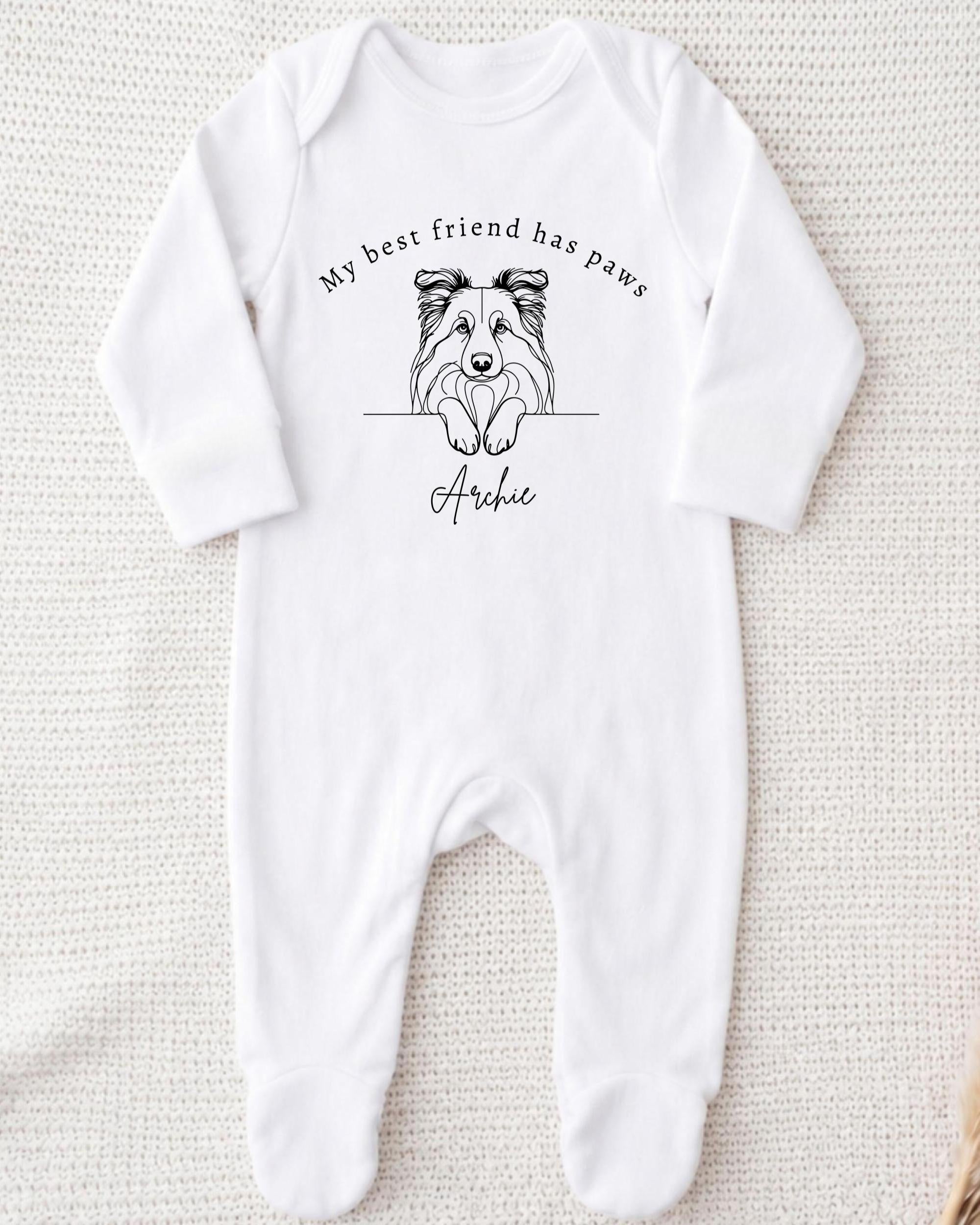 A white onesie with a black and white illustration of a dog's face and the text "My best friend has paws" printed on it.