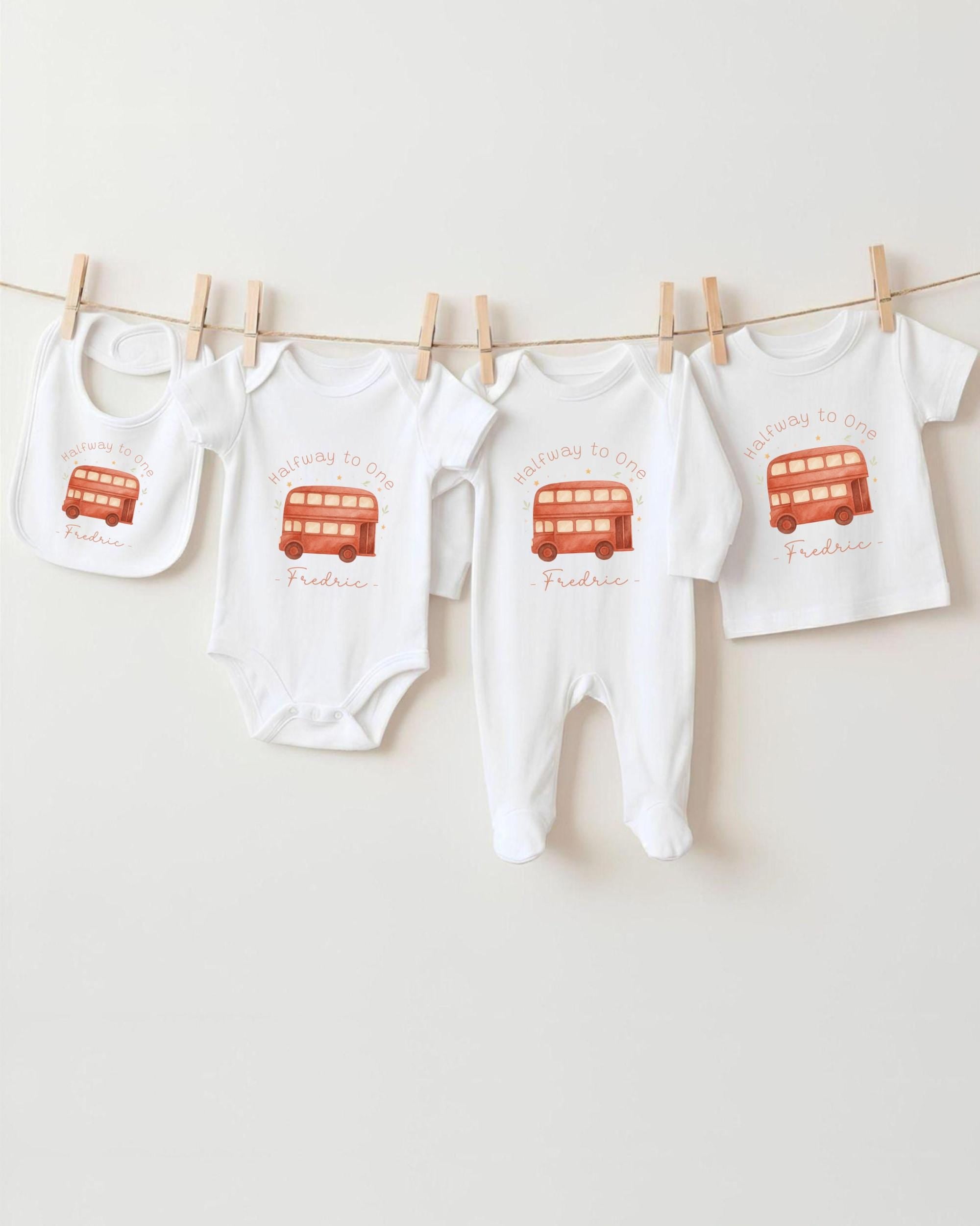 A collection of baby clothing items, including onesies and bibs, hanging on a clothesline.