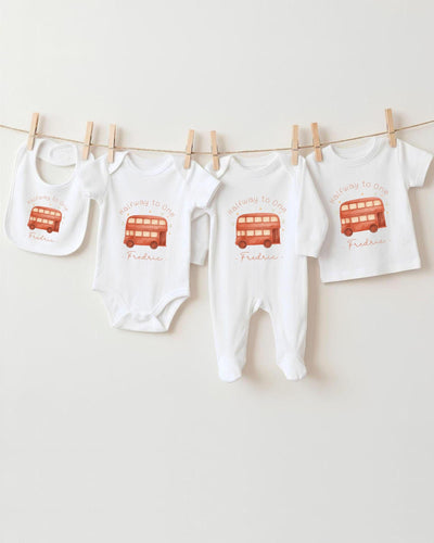 A collection of baby clothing items, including onesies and bibs, hanging on a clothesline.