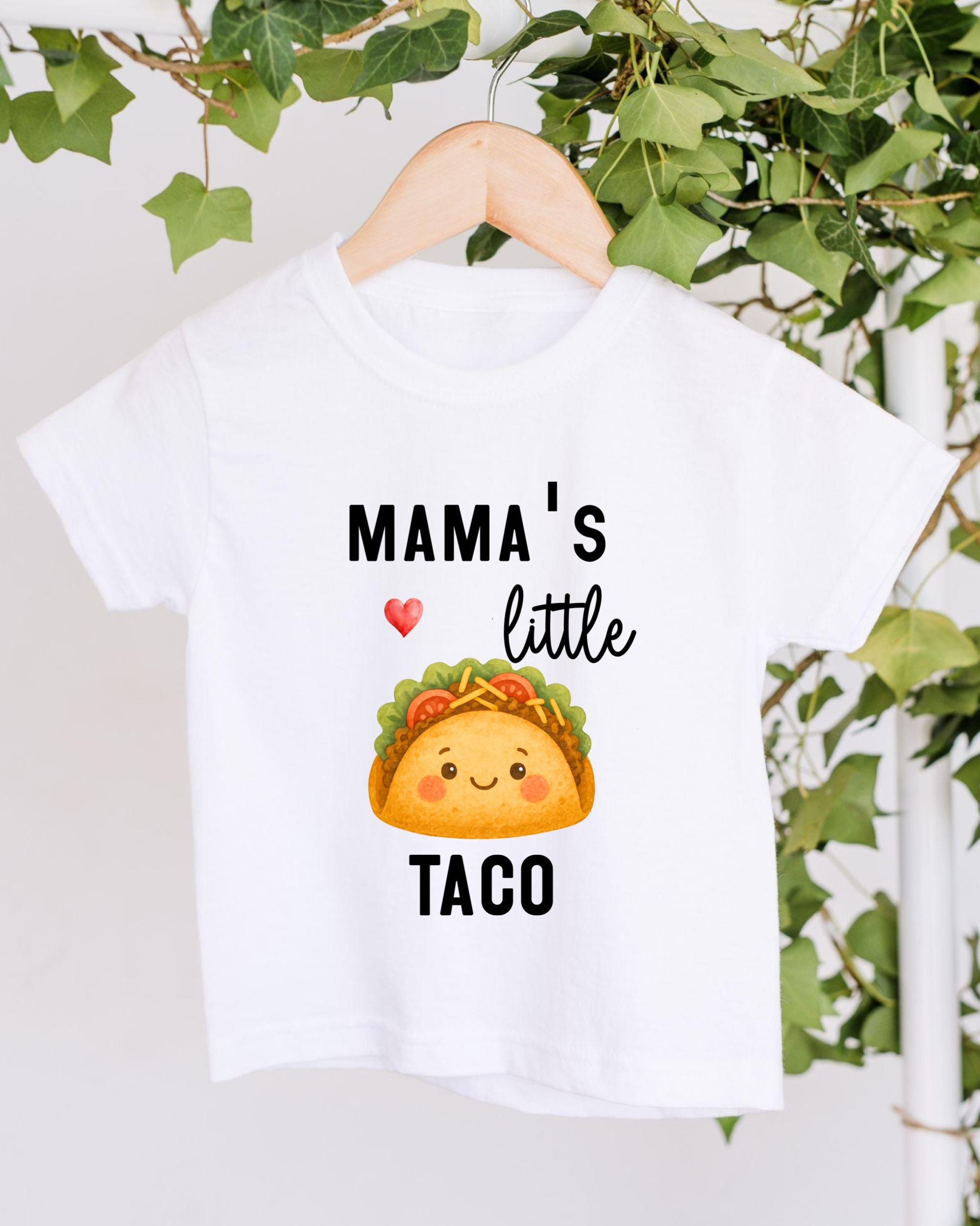 A white t-shirt with a graphic design of a taco and the text "Mama's little taco" printed on it.