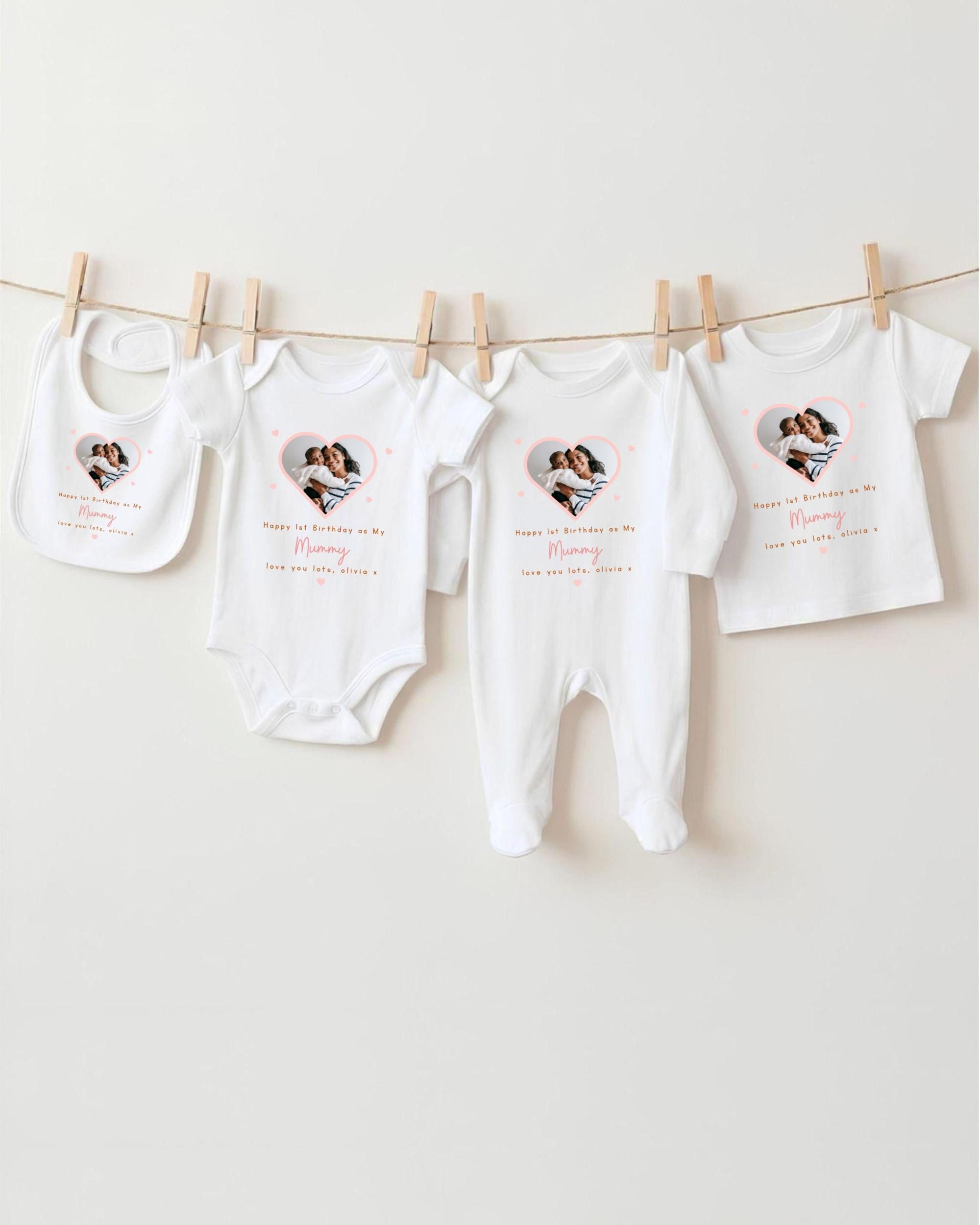 a collection of baby clothes hanging on a clothesline, with each piece featuring a heart design and personalized text.