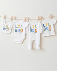 A row of four white baby clothes with the text "LIL BRO Oscar" printed on them, hanging on a clothesline.