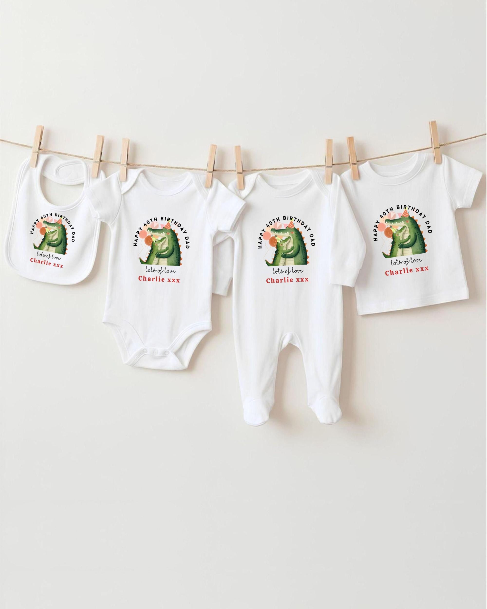 A collection of white baby clothes, including onesies and bibs, hanging on a clothesline.