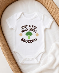 A white onesie with the text "JUST A KID WHO LOVES BROCCOLI" printed on it, along with a broccoli graphic.