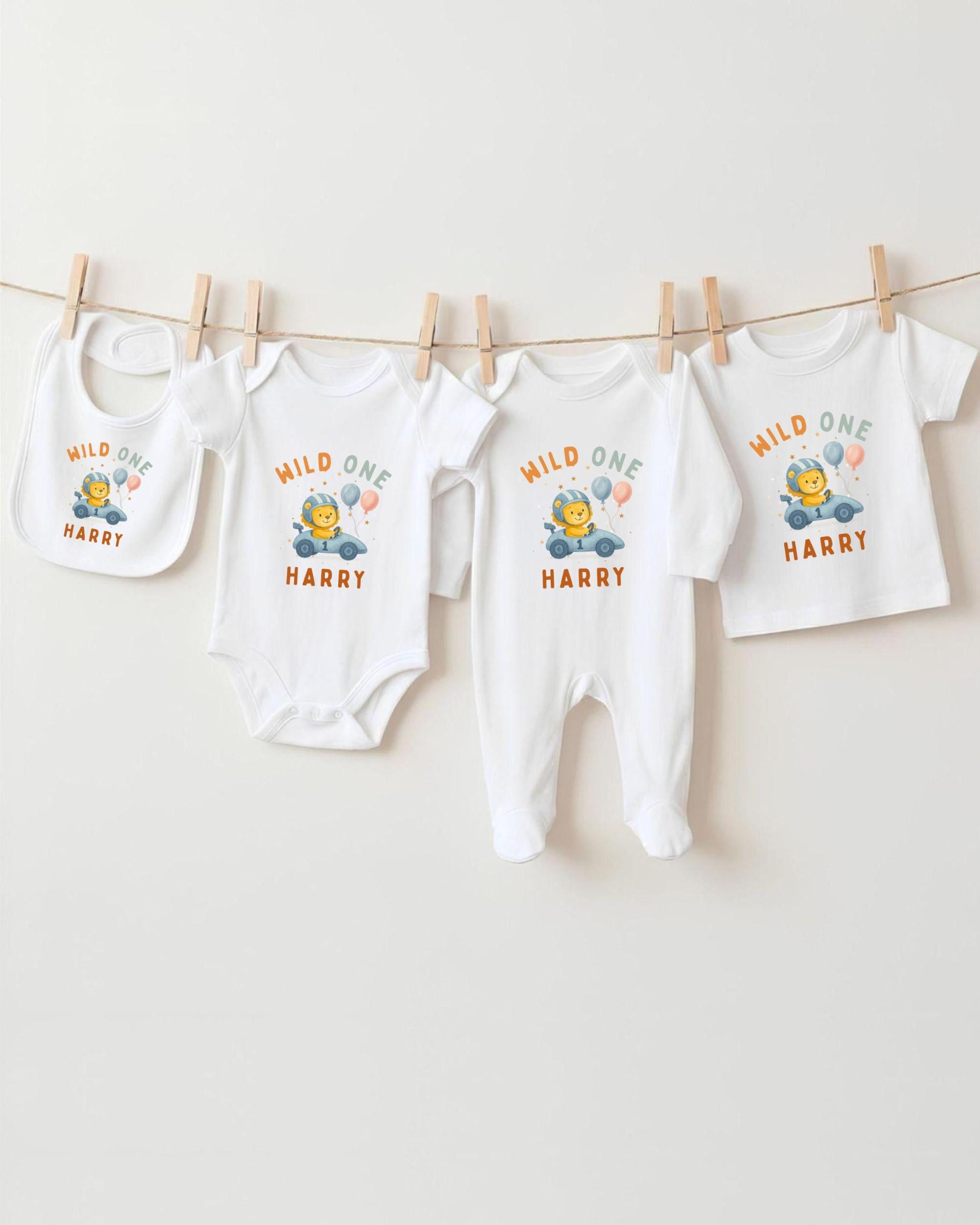 A collection of white baby clothes, including onesies and bibs, hanging on a clothesline.