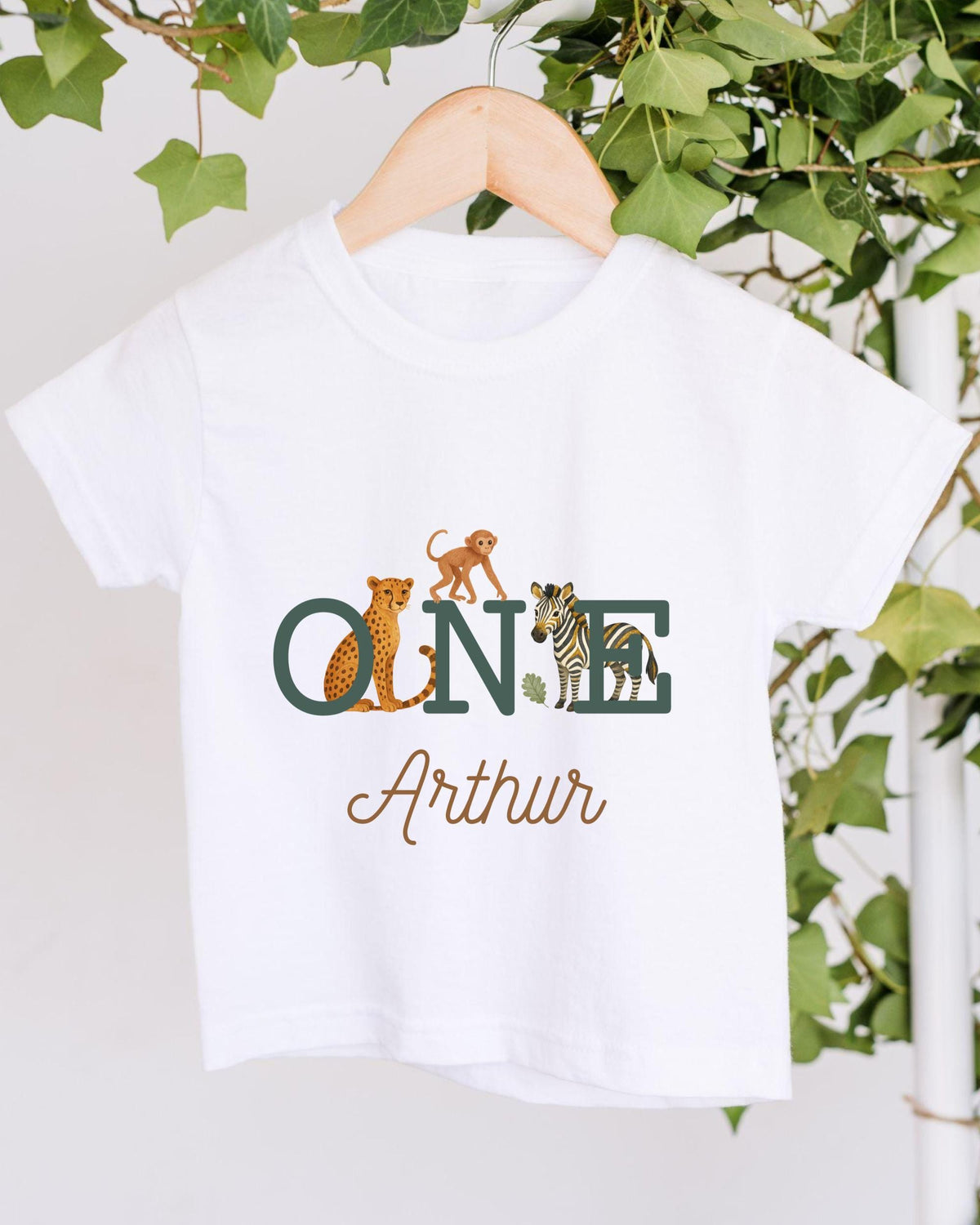 A white t-shirt with a graphic design featuring a monkey, zebra, and leopard, along with the text "ONE Arthur" printed on it.