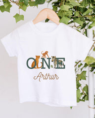 A white t-shirt with a graphic design featuring a monkey, zebra, and leopard, along with the text "ONE Arthur" printed on it.