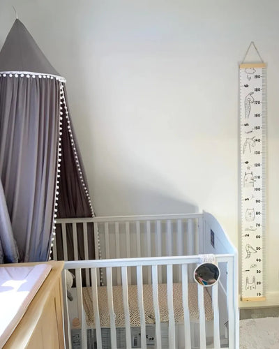 a baby crib with a measuring tape next to it