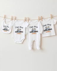 A collection of white baby clothes, including onesies and bibs, hanging on a clothesline.