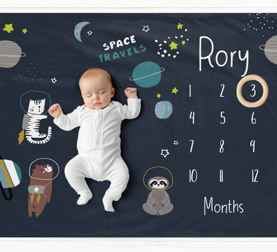 a baby is laying on a chalkboard with space images