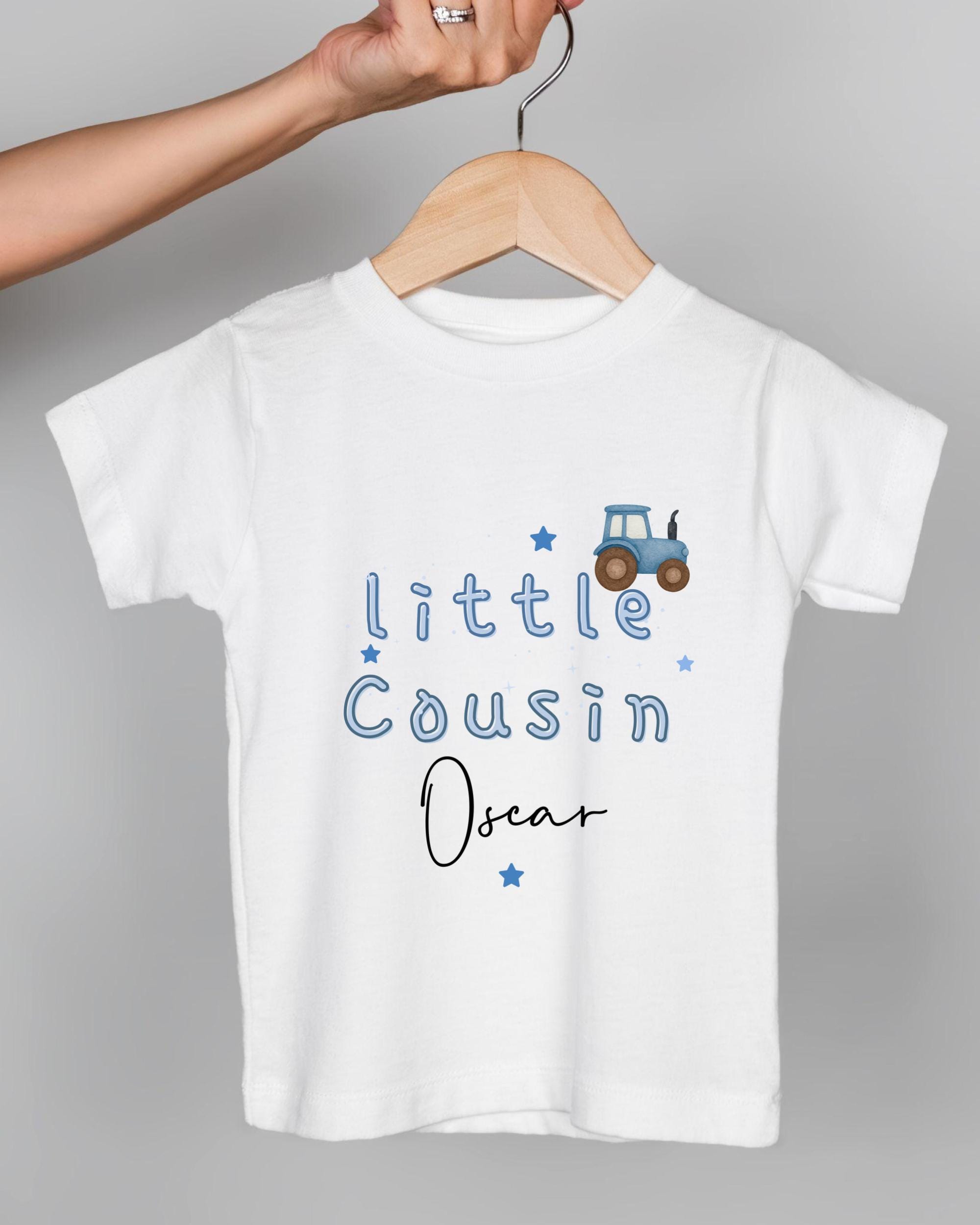 A white t-shirt with blue text and a tractor graphic printed on it.