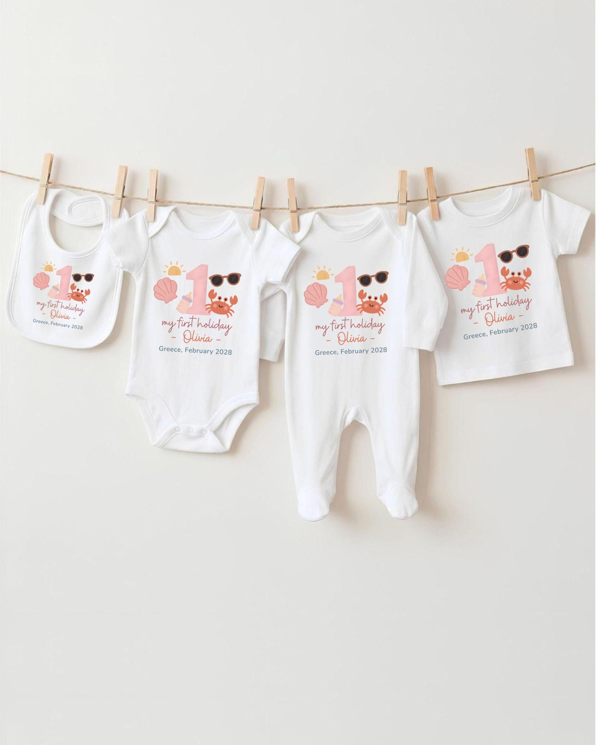 A collection of baby clothes, including onesies and bibs, hanging on a clothesline.