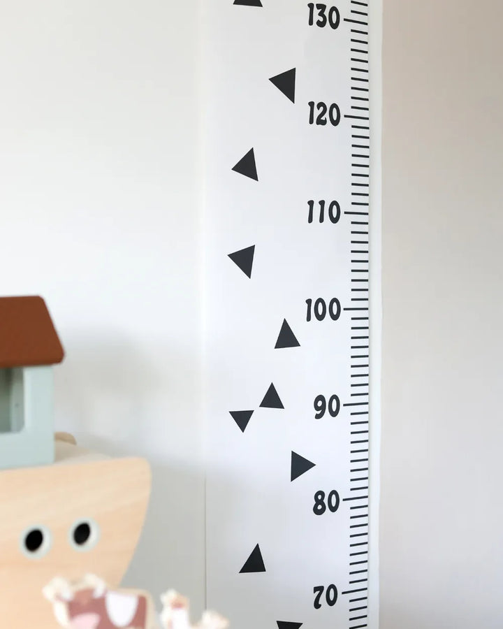a child's room with a white wall and a black and white growth chart