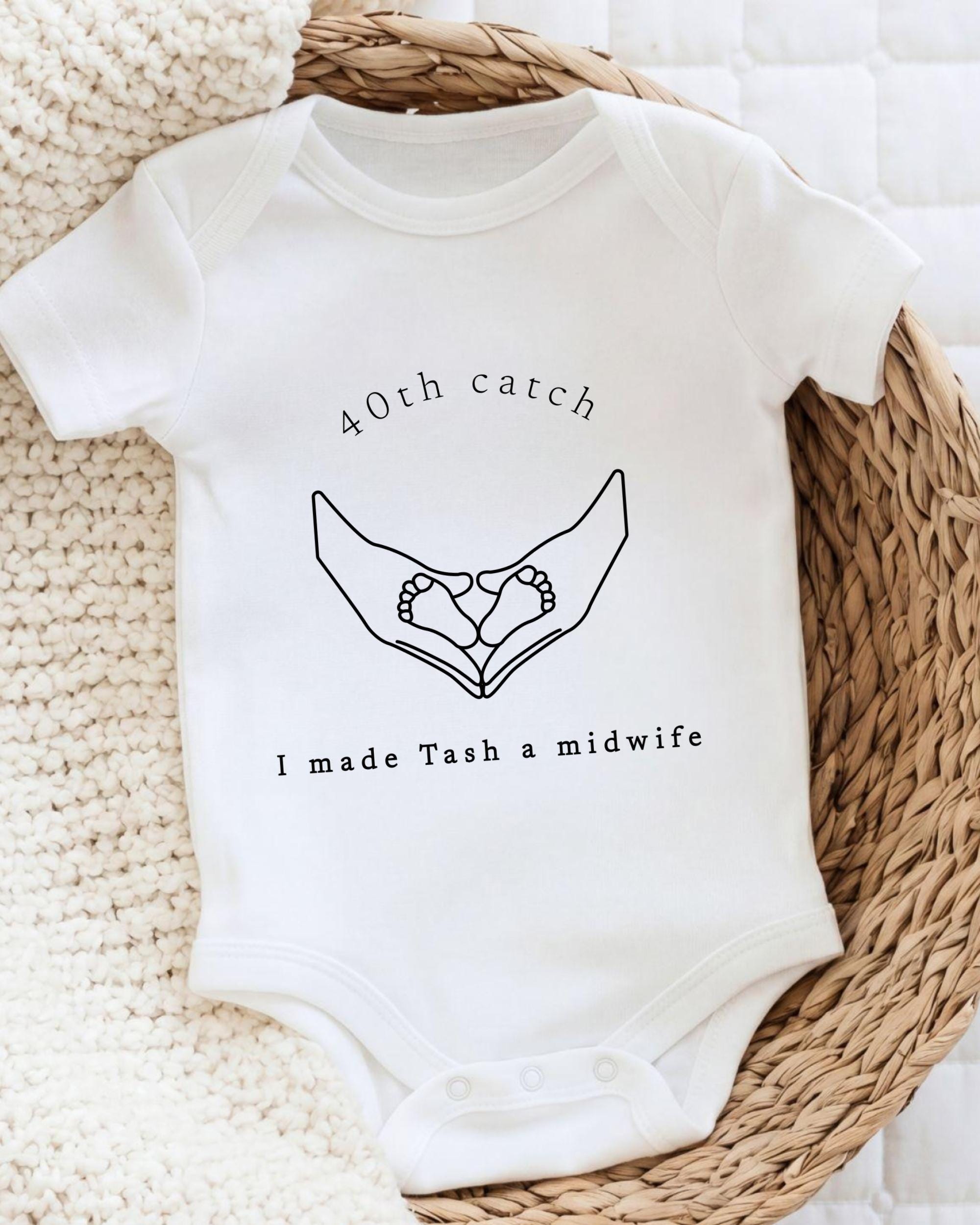 A white baby onesie with a graphic design and text printed on it.