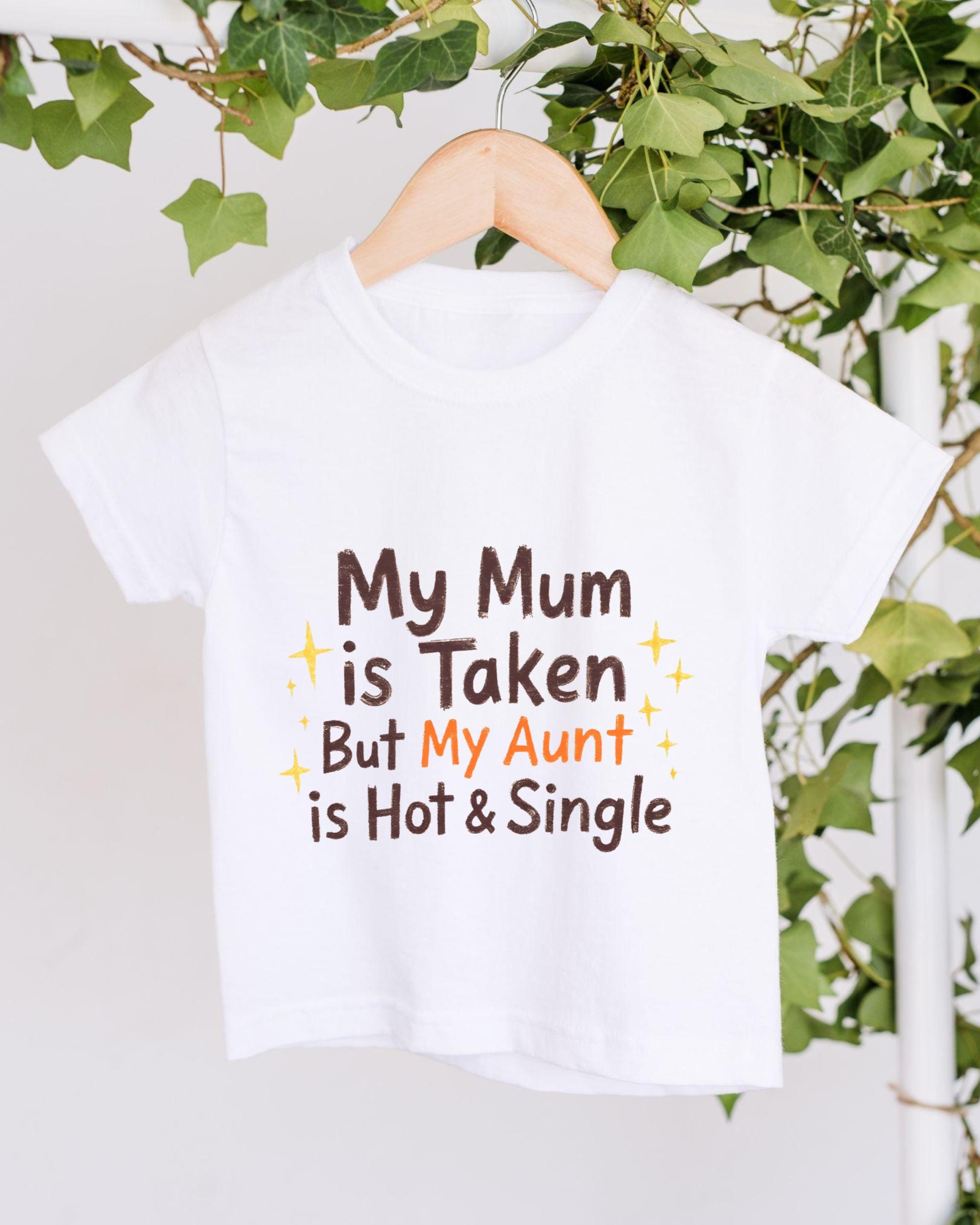 A white t-shirt with text printed on it, hanging on a wooden hanger.