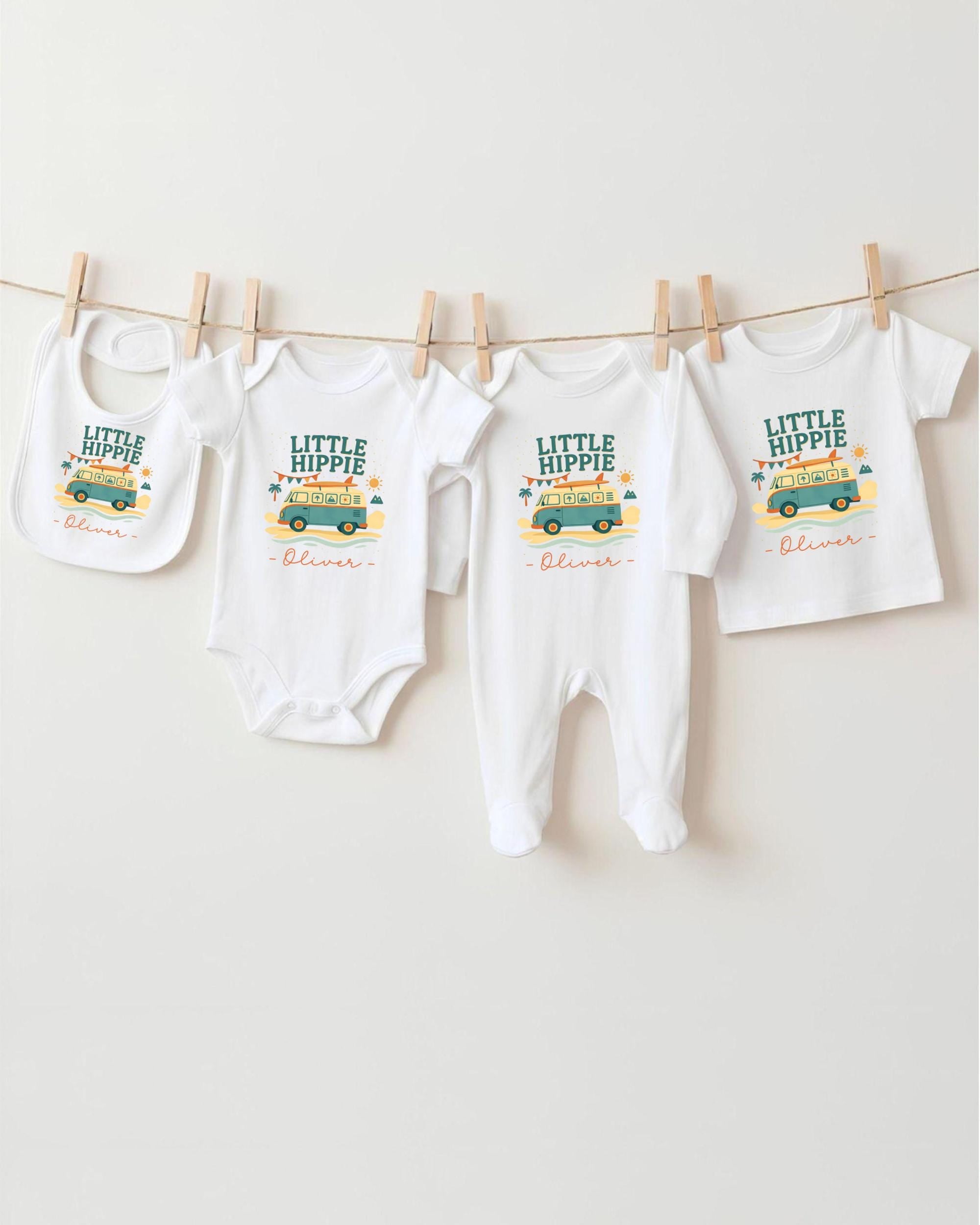 A collection of baby clothes, including onesies and bibs, hanging on a clothesline.