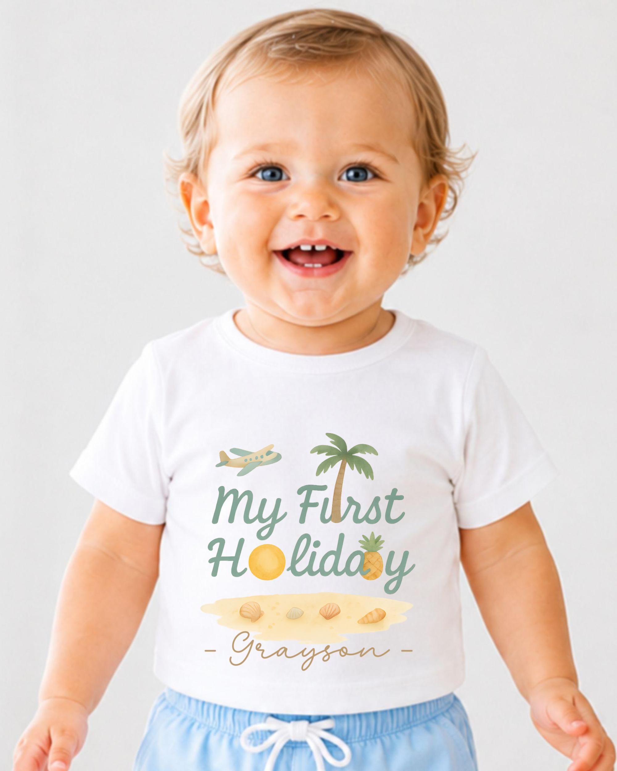 A smiling baby wearing a white t-shirt with a graphic design and text printed on it.