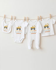 A collection of baby clothes, including onesies and pants, hanging on a clothesline.
