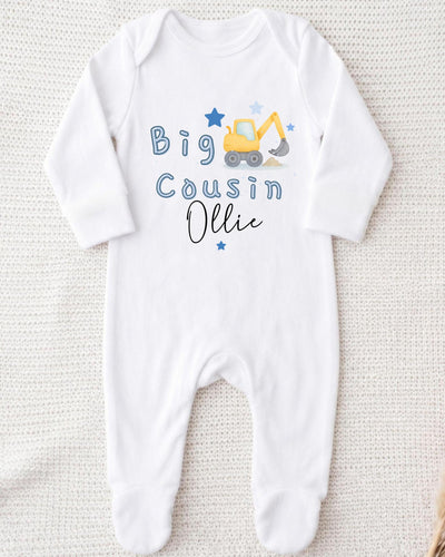 A white bodysuit with a graphic of a yellow excavator and the text "Big Cousin Ollie" printed on it.