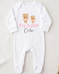 A white onesie with a design featuring two teddy bears and the text "Big Sister Chloe" printed on it.