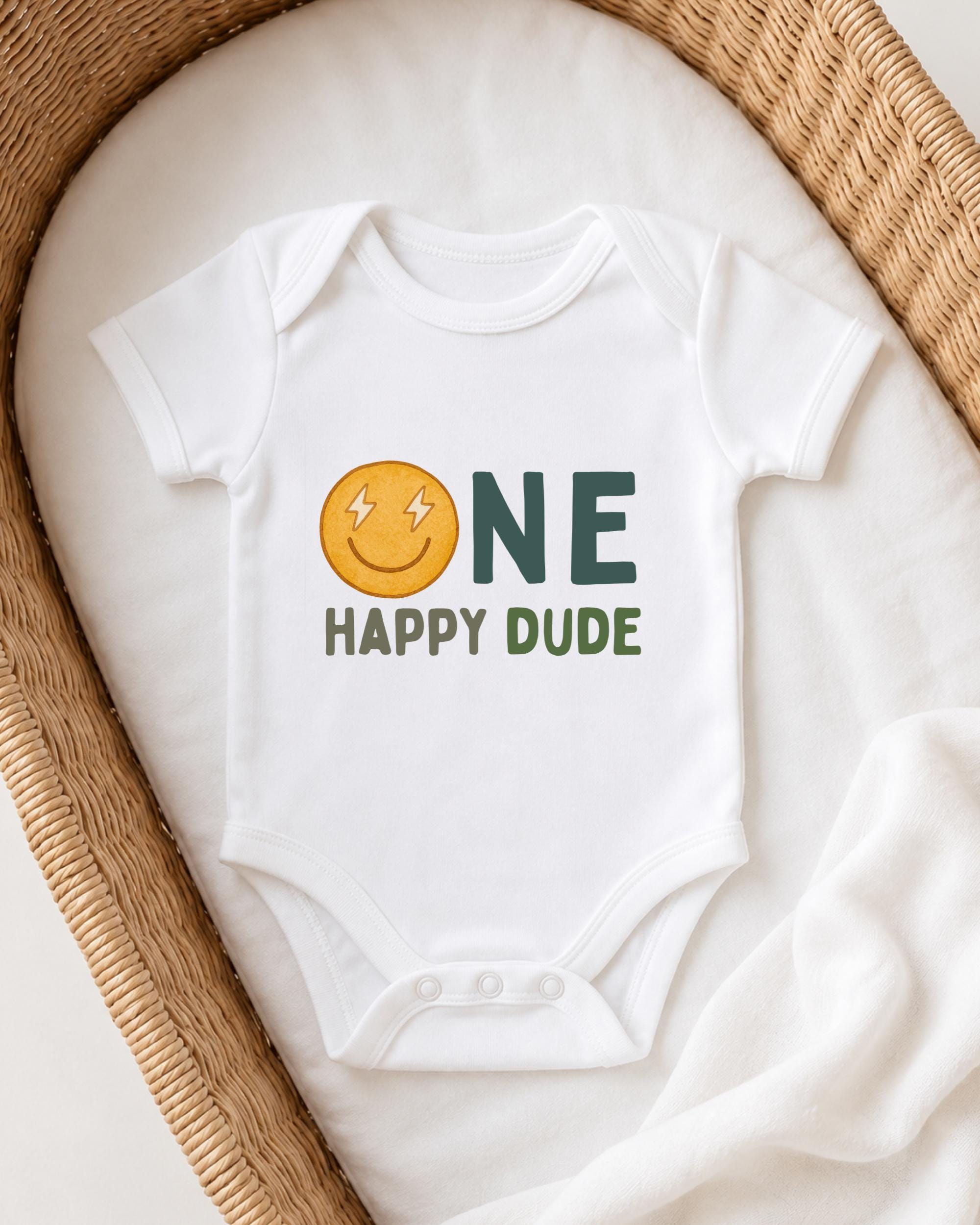 A white onesie with a smiley face and the text "ONE HAPPY Dude" printed on it, laid out on a white blanket.