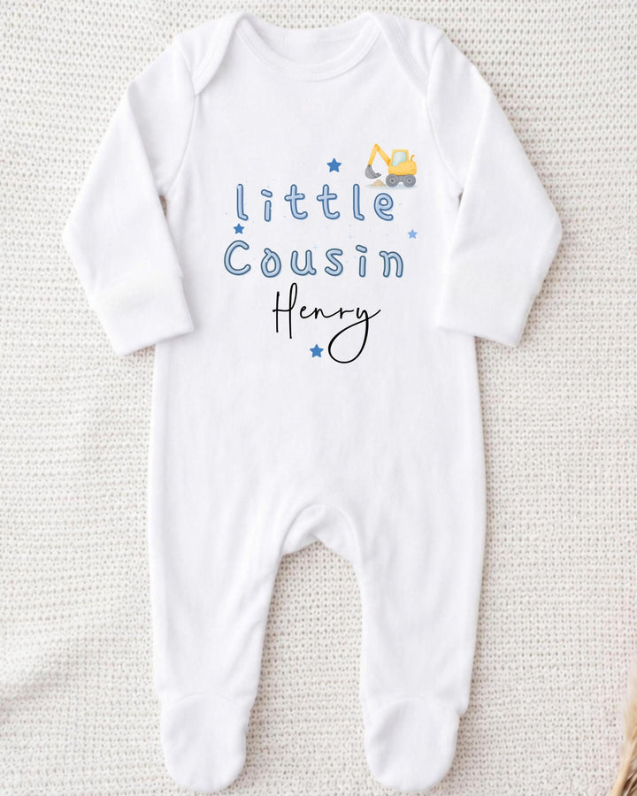 A white onesie with blue text and a small construction vehicle graphic printed on it.