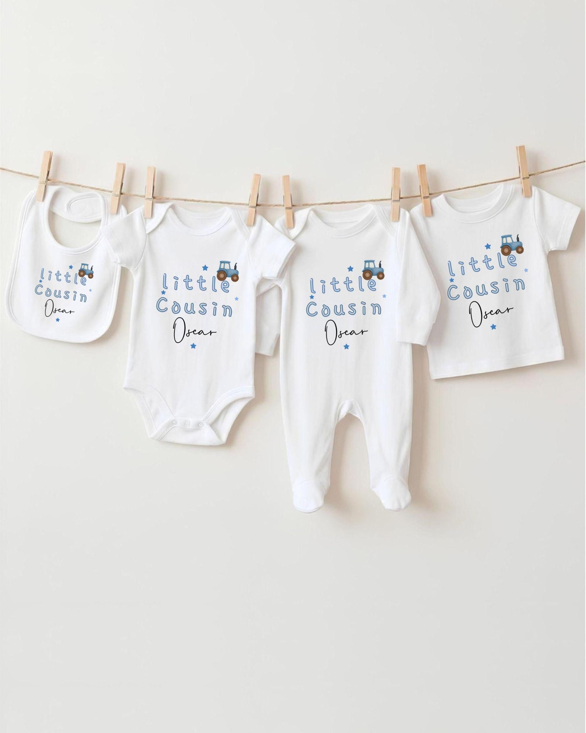 A row of baby clothes, including onesies and bibs, hanging on a clothesline.