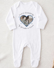 A white onesie with a heart-shaped photo of a man and a child printed on it, along with the text "Loved & Protected by my Grandpa in Heaven".