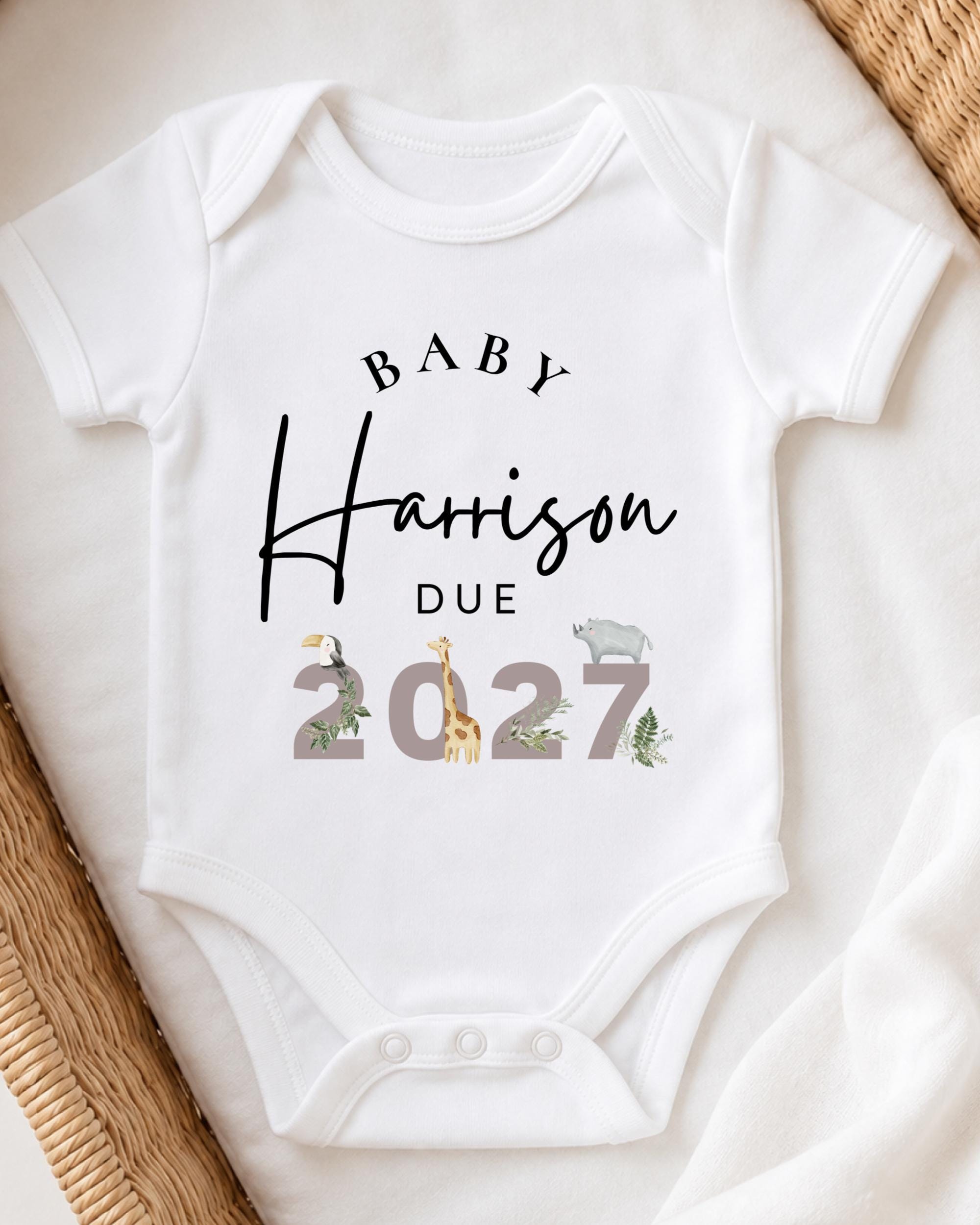 A white baby onesie with text and illustrations printed on it.