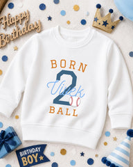 A white sweatshirt with the text "BORN 2 VIEK BALL" printed on it, surrounded by birthday decorations such as a crown, confetti, and a birthday hat.