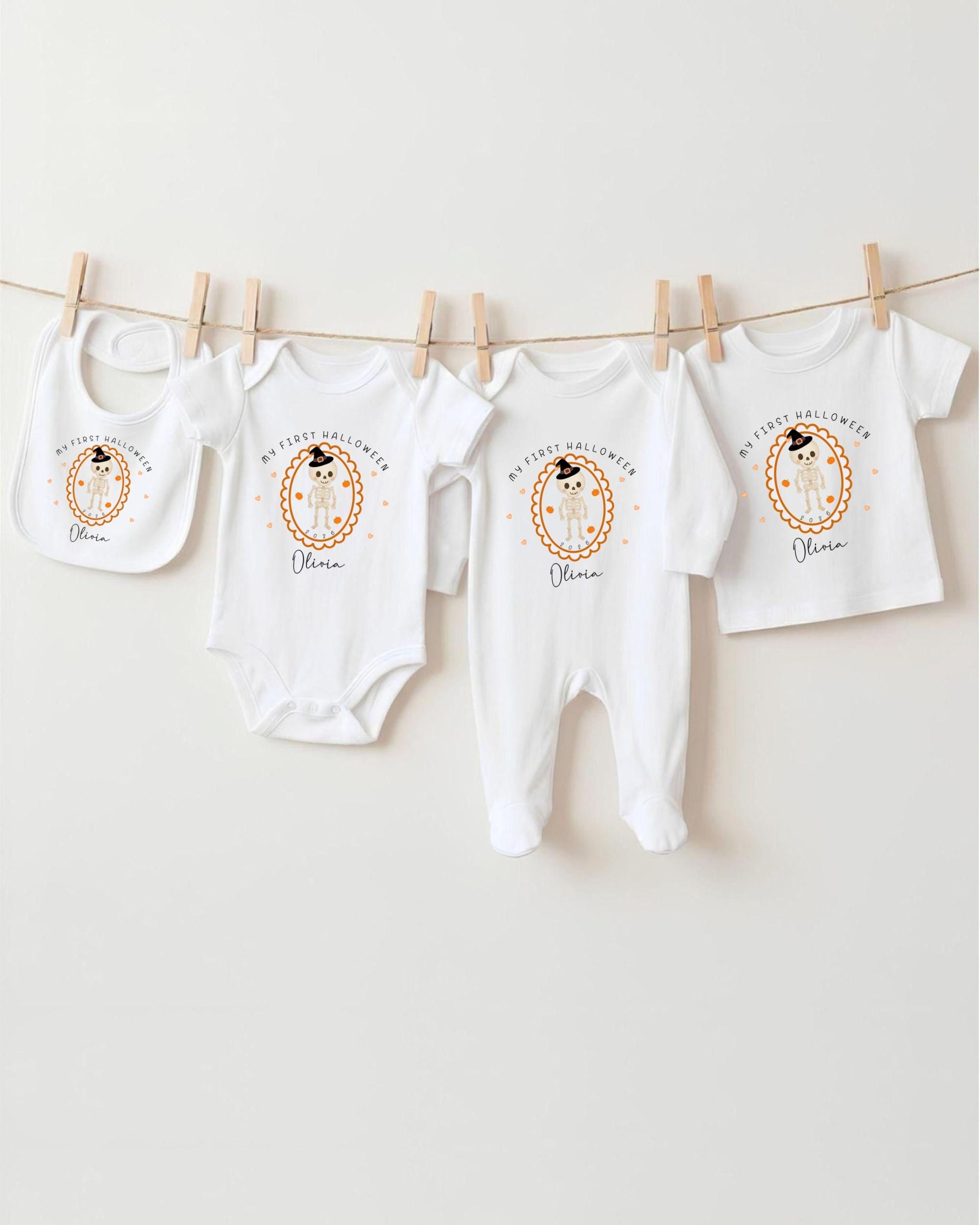 A row of white baby clothes, including onesies and bibs, hanging on a clothesline.